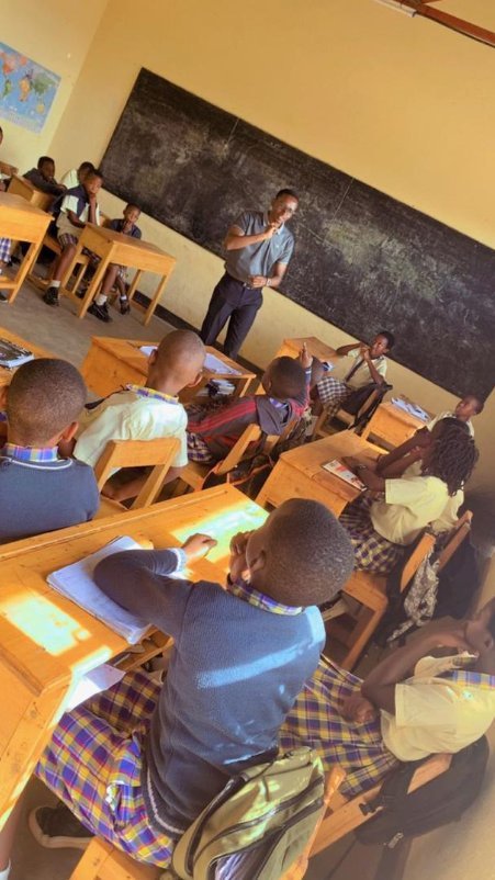 Oral health education session in a Rwandan classroom, students and teacher at chalkboard
