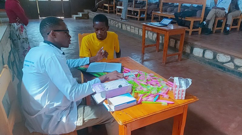 RDMS dental professional working with patient at a mobile clinic field setup, Rwanda 2024